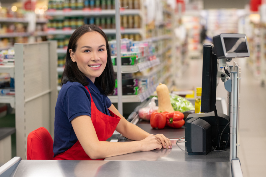Frau arbeitet im Supermarkt als Kassiererin